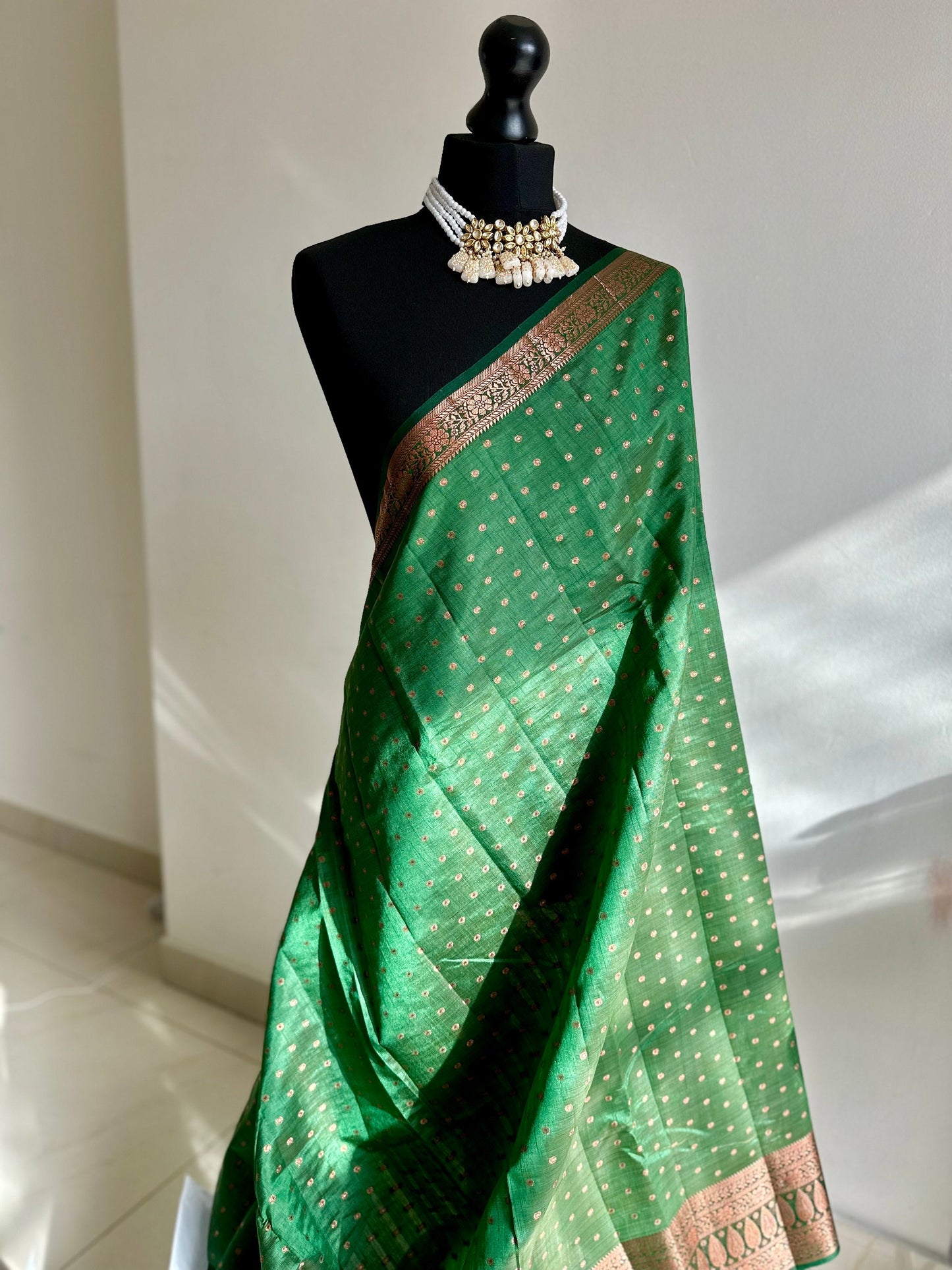 Dark green soft raw tussar silk saree with border and unstitched blouse. Copper work all over and border. Statement saree and colour