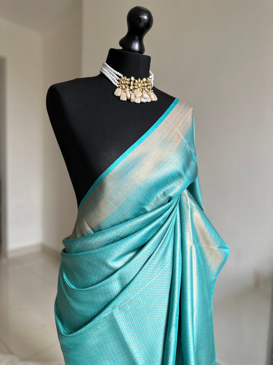 Light blue aqua soft silk saree with a copper border and all over sheen. The perfect saree for parties and all traditional events.