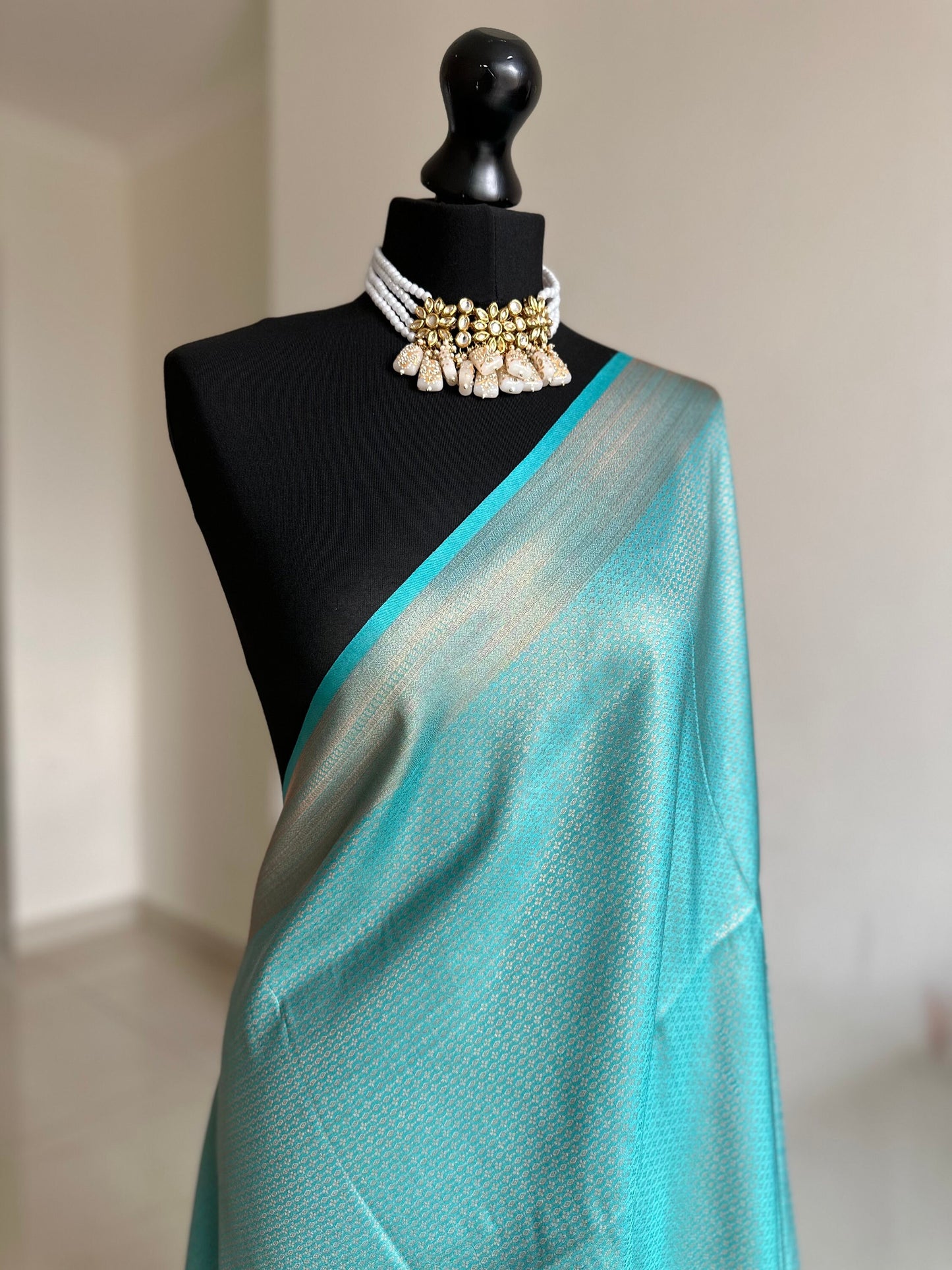 Light blue aqua soft silk saree with a copper border and all over sheen. The perfect saree for parties and all traditional events.