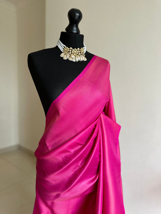 Hot pink soft silk saree with a copper border and all over sheen. The perfect saree for parties and all traditional events.