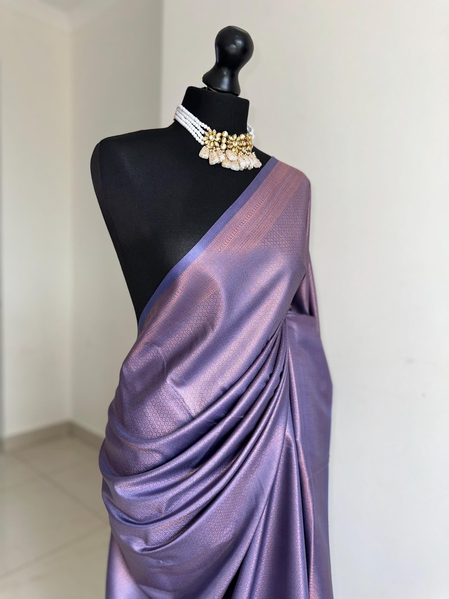 Dusty purple soft silk saree with a copper border and all over sheen. The perfect saree for parties and all traditional events.