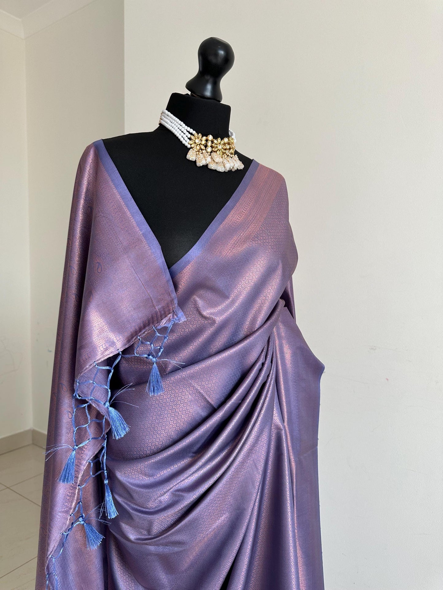 Dusty purple soft silk saree with a copper border and all over sheen. The perfect saree for parties and all traditional events.