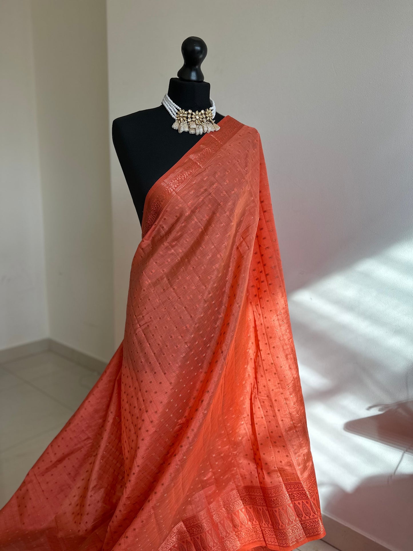 Orange coral soft tussar silk saree with border and unstitched blouse. Copper work all over and border. Statement saree and colour,stand out