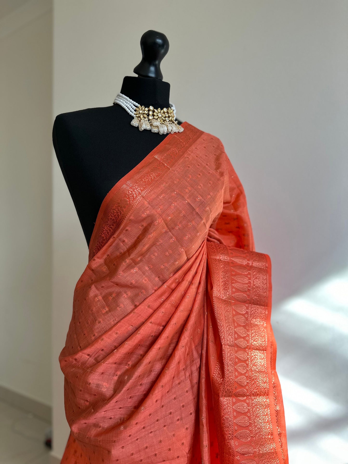 Orange coral soft tussar silk saree with border and unstitched blouse. Copper work all over and border. Statement saree and colour,stand out