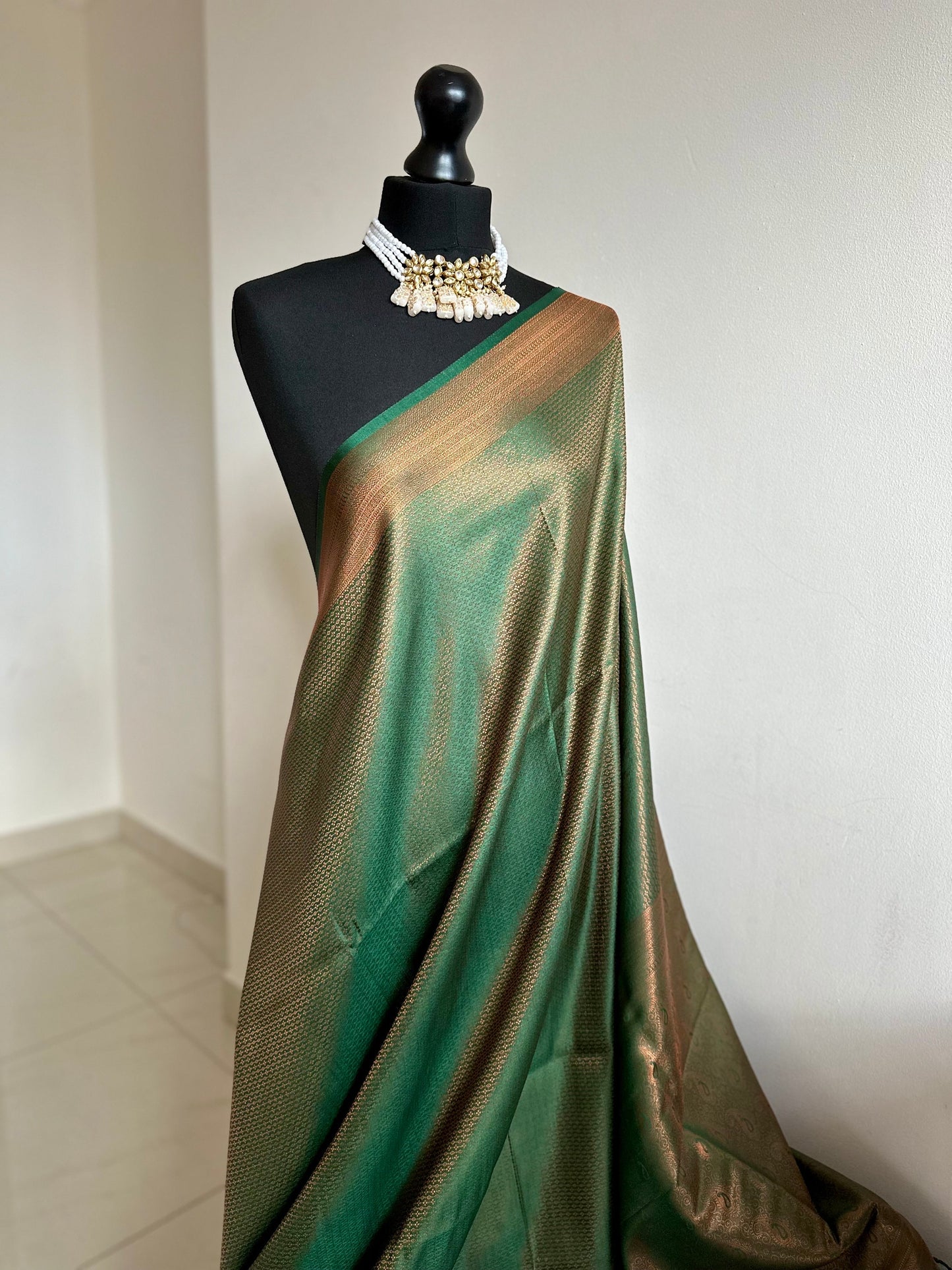 Bottle green silk saree with a copper border and all over sheen. The perfect saree for parties and all traditional events. Versatile saree