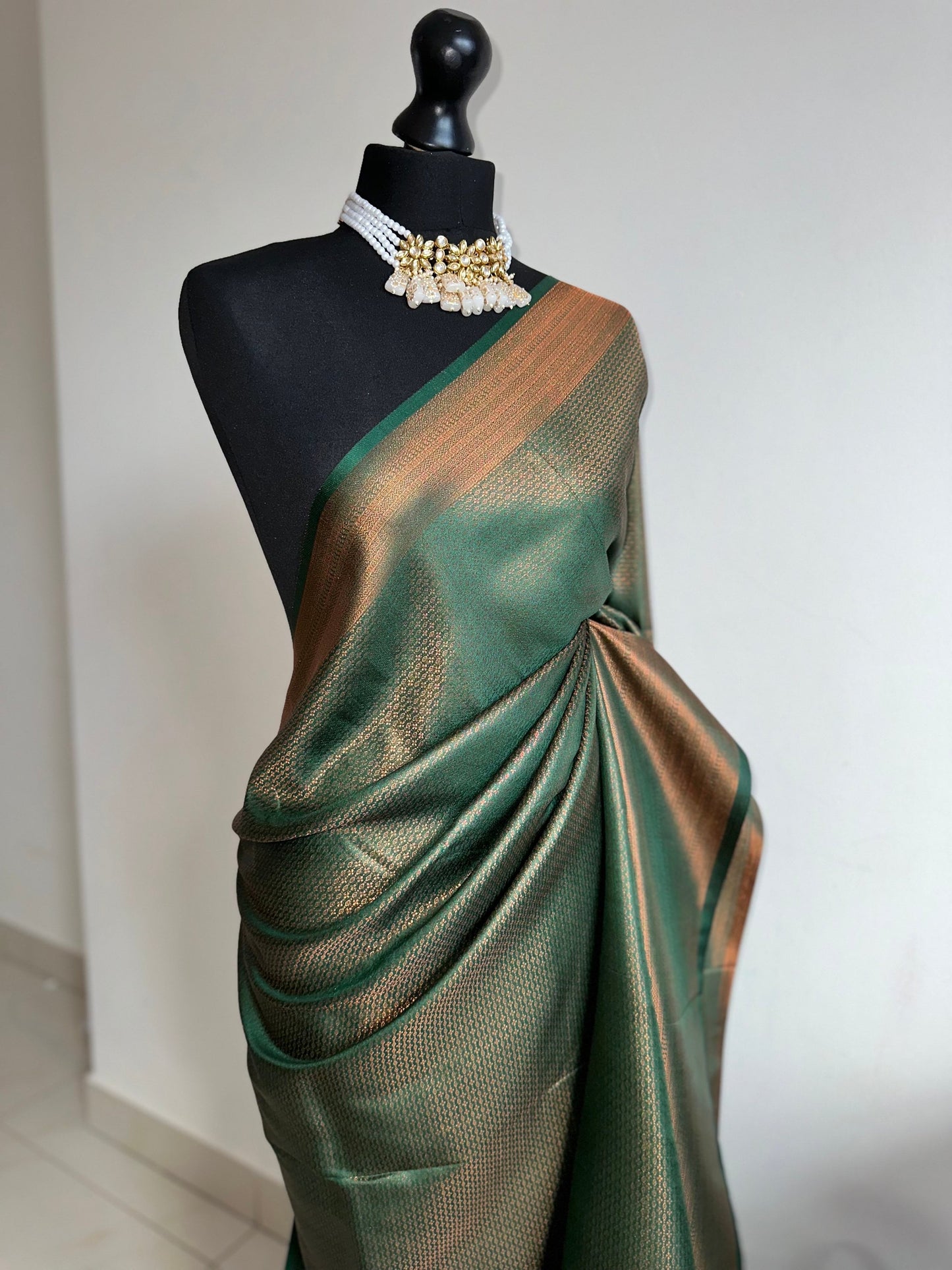 Bottle green silk saree with a copper border and all over sheen. The perfect saree for parties and all traditional events. Versatile saree