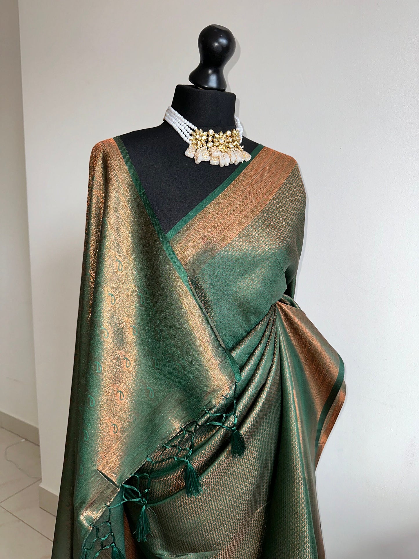 Bottle green silk saree with a copper border and all over sheen. The perfect saree for parties and all traditional events. Versatile saree