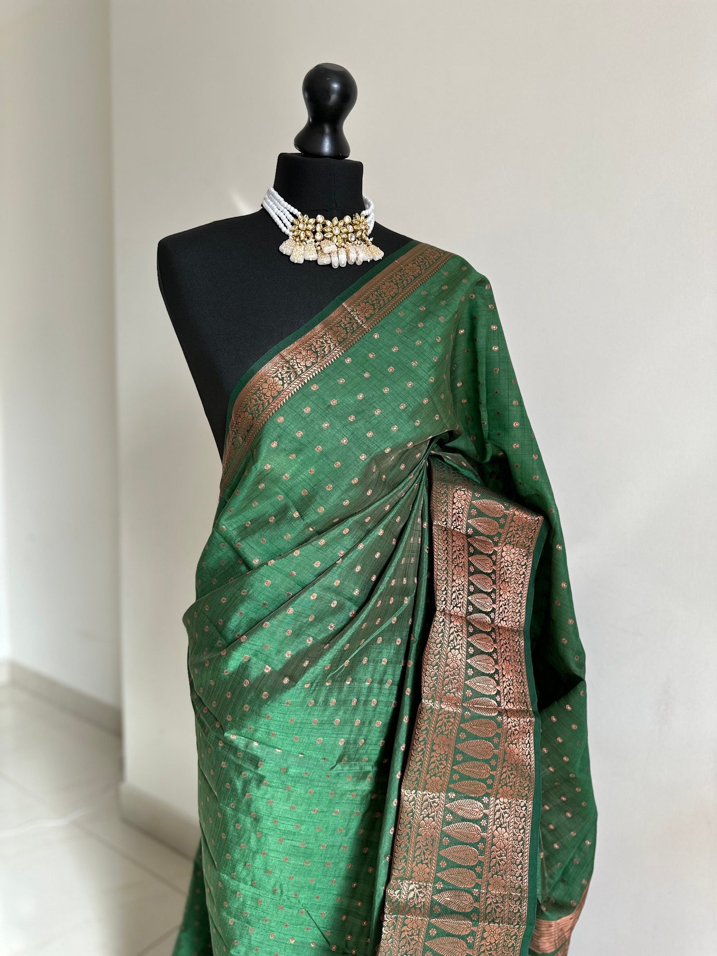 Dark green soft raw tussar silk saree with border and unstitched blouse. Copper work all over and border. Statement saree and colour