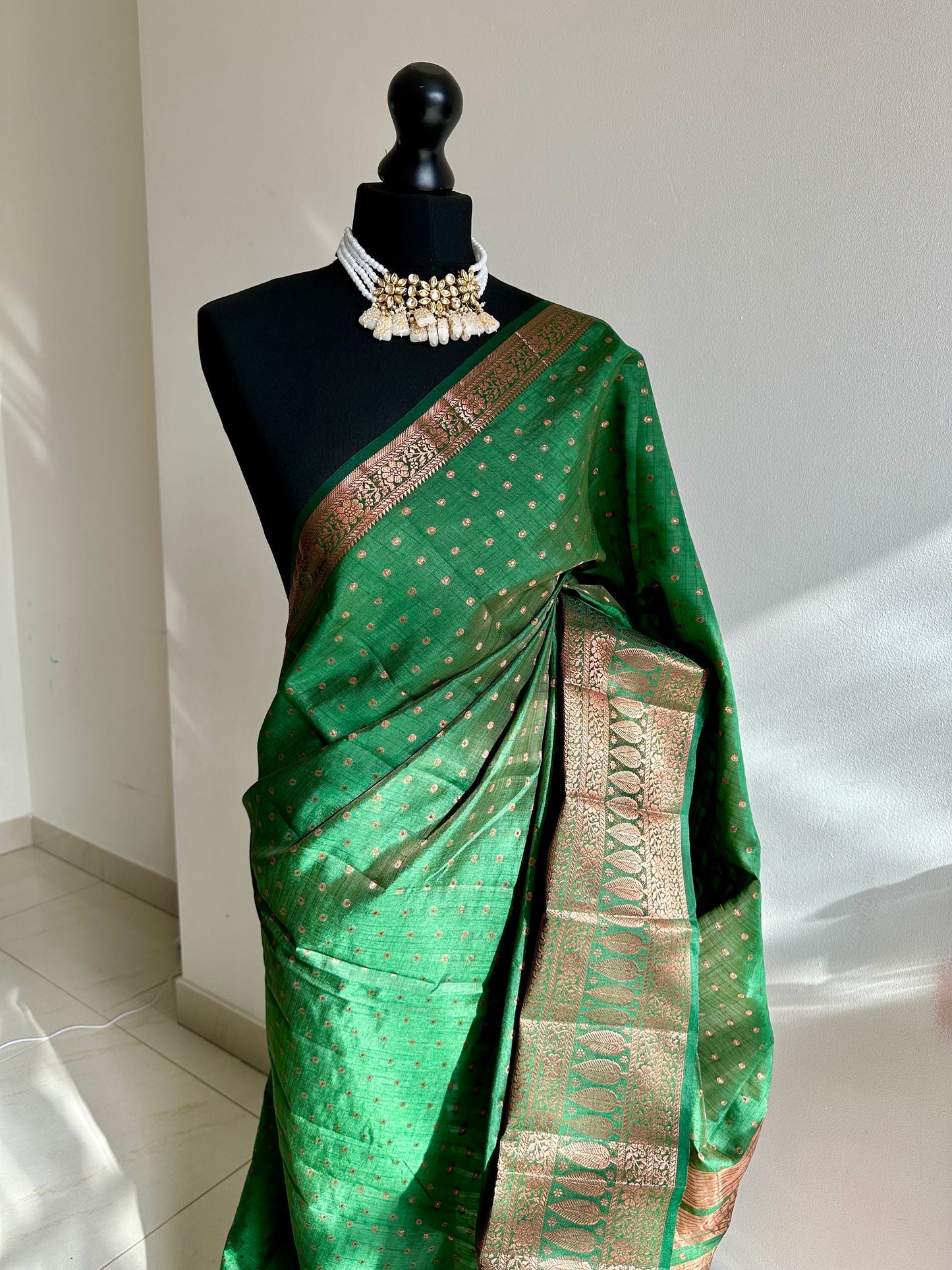 Dark green soft raw tussar silk saree with border and unstitched blouse. Copper work all over and border. Statement saree and colour