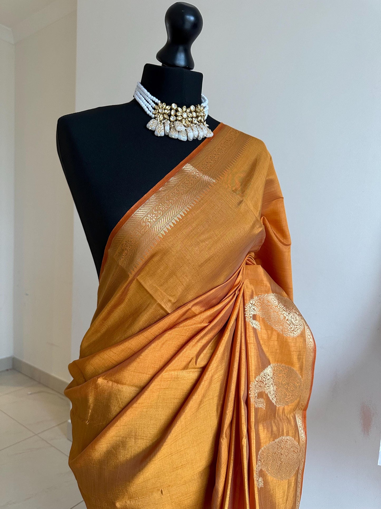 Sandal wood orange soft tussar raw silk saree with unstitched blouse. Gold work on border and pallu. Statement saree and colour.