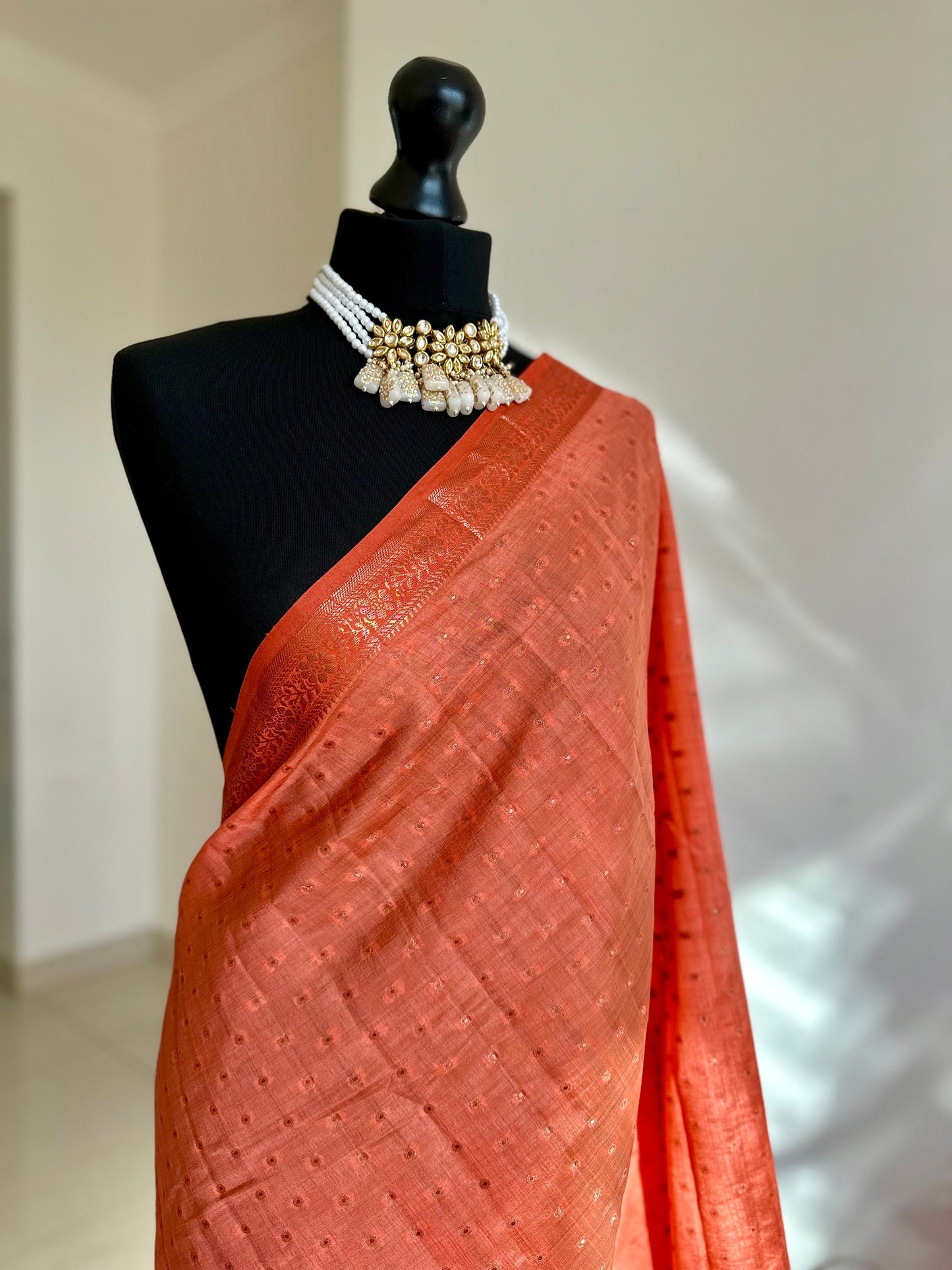 Orange coral soft tussar silk saree with border and unstitched blouse. Copper work all over and border. Statement saree and colour,stand out