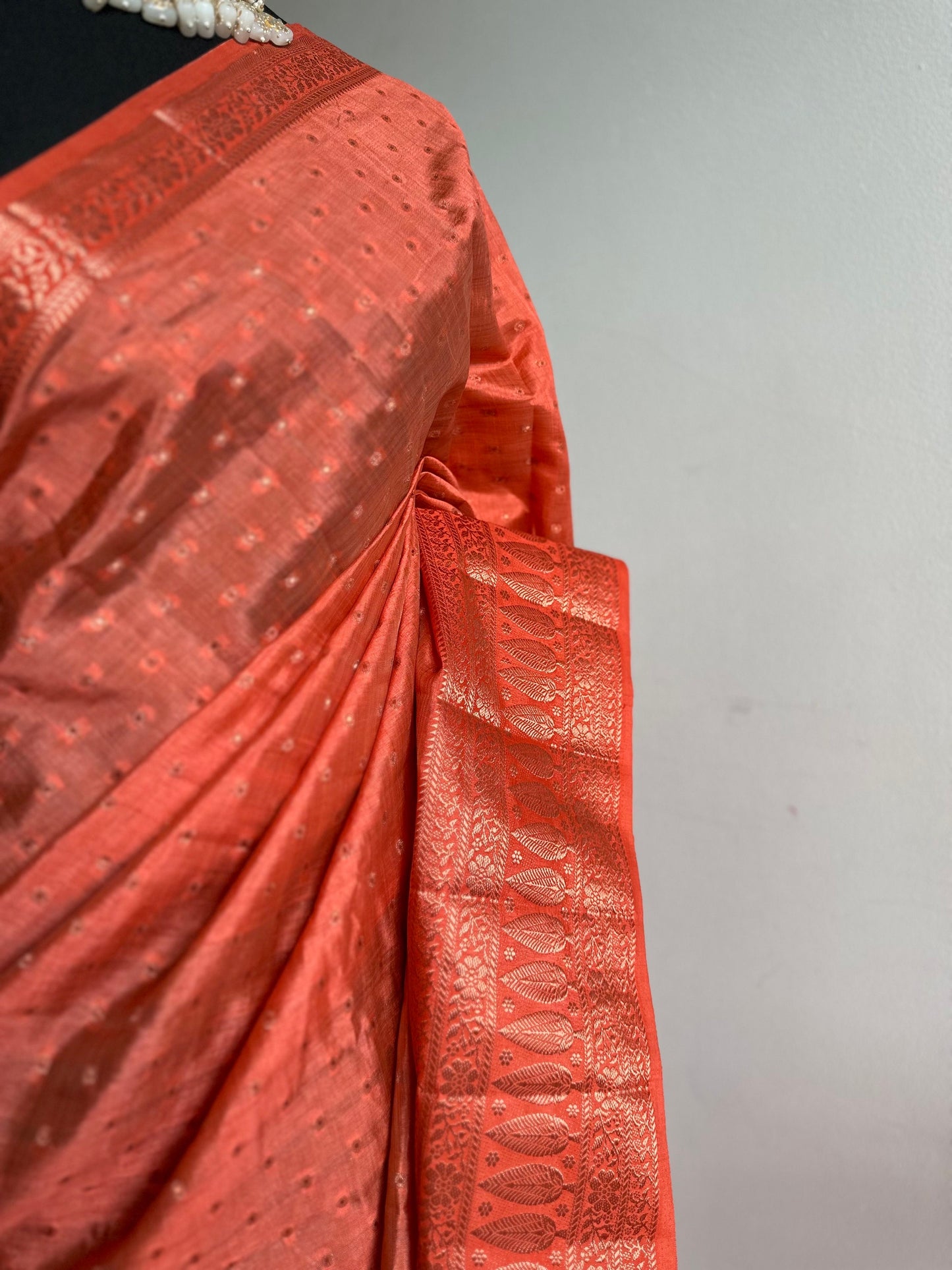 Orange coral soft tussar silk saree with border and unstitched blouse. Copper work all over and border. Statement saree and colour,stand out