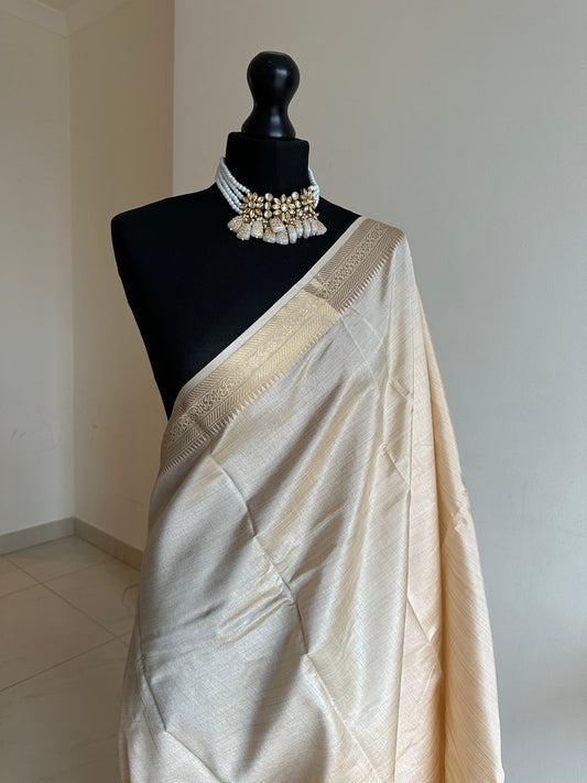 Cream soft tussar raw silk saree with unstitched blouse. Gold work on border and pallu. Statement saree and colour.