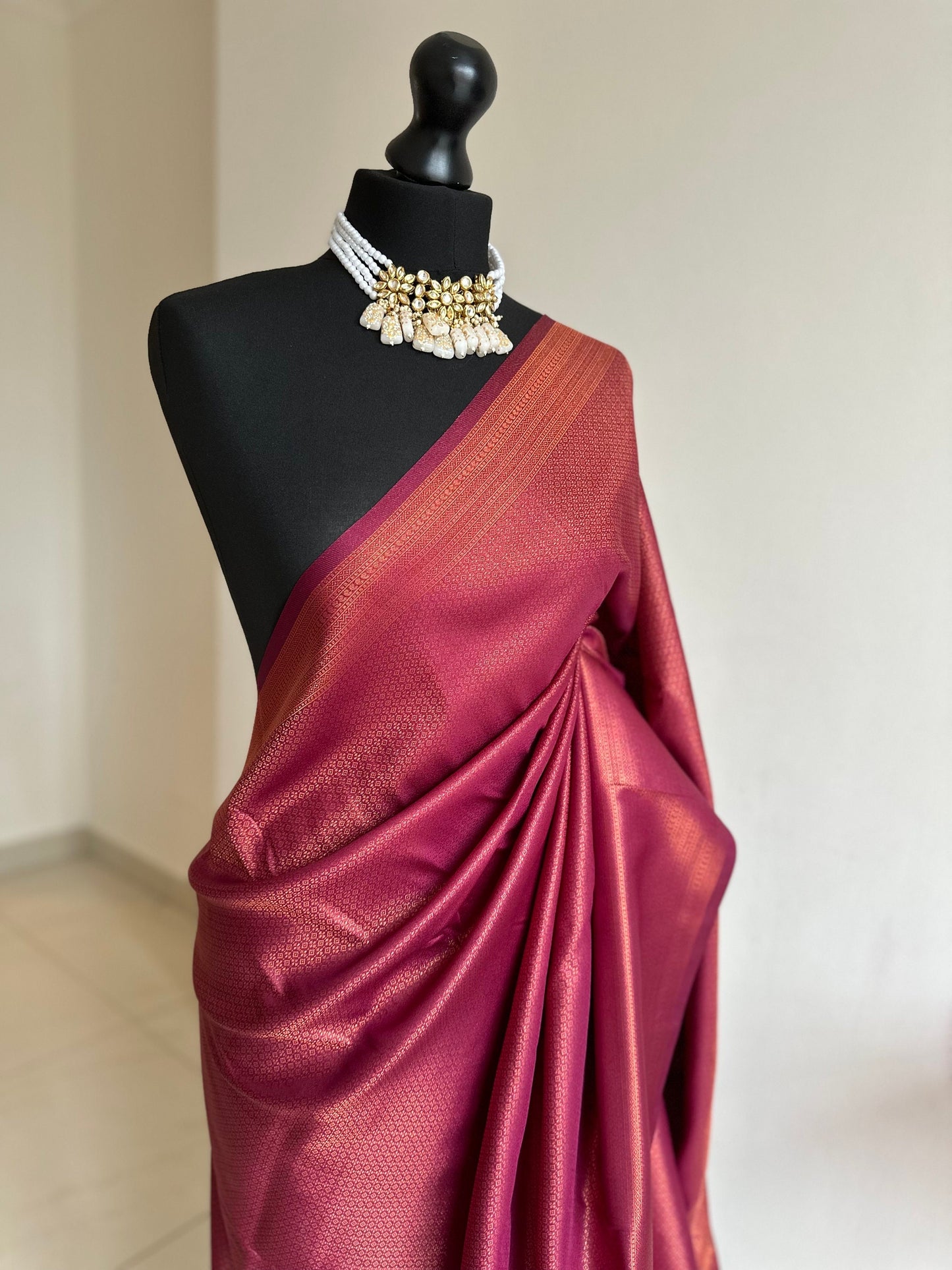 Wine burgundy soft silk saree with copper border and all over sheen. The perfect saree for parties all traditional events.Versatile saree