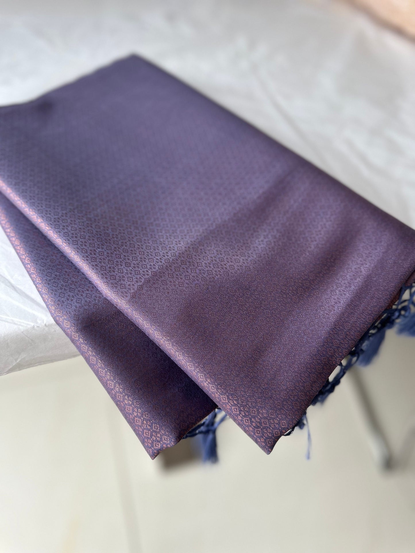 Dusty purple soft silk saree with a copper border and all over sheen. The perfect saree for parties and all traditional events.