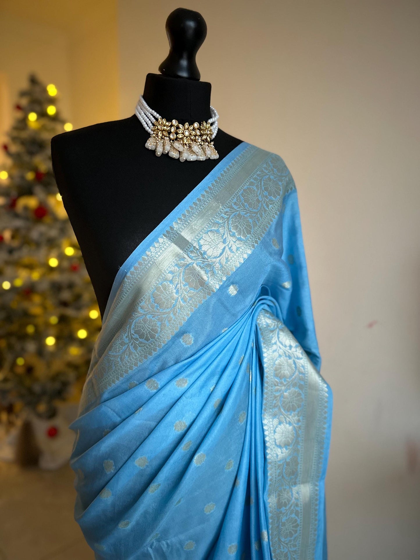 Pale blue banarasi faux gerogette saree. Silver border to create a sophisticated look, worked pallu with tassels with designer blouse