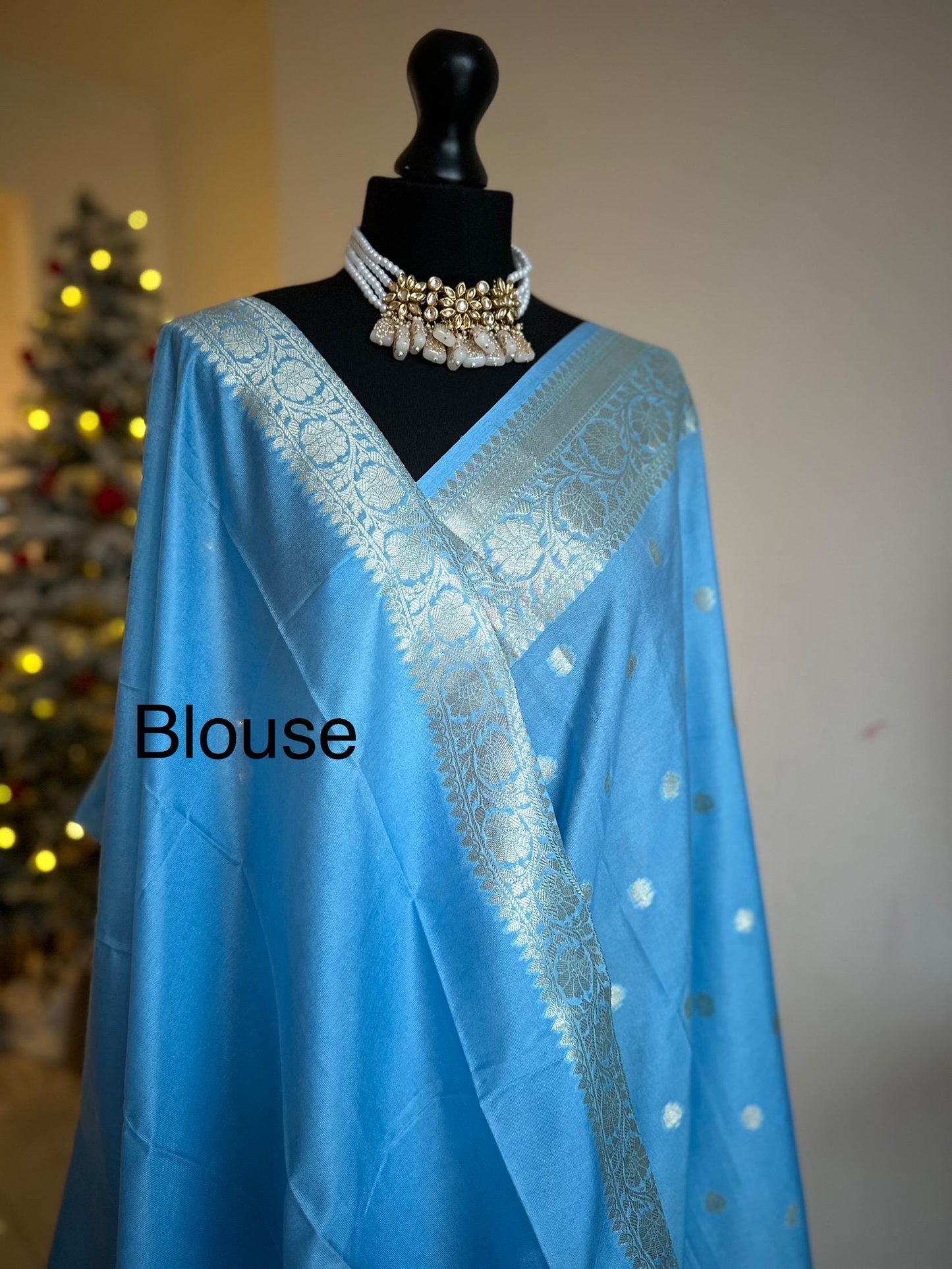 Pale blue banarasi faux gerogette saree. Silver border to create a sophisticated look, worked pallu with tassels with designer blouse