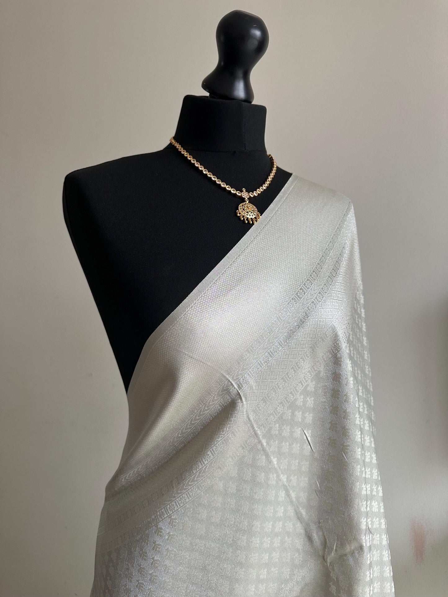 Off white and silver soft silk saree with an all over sheen. The perfect saree for parties and all traditional events.White saree for guests