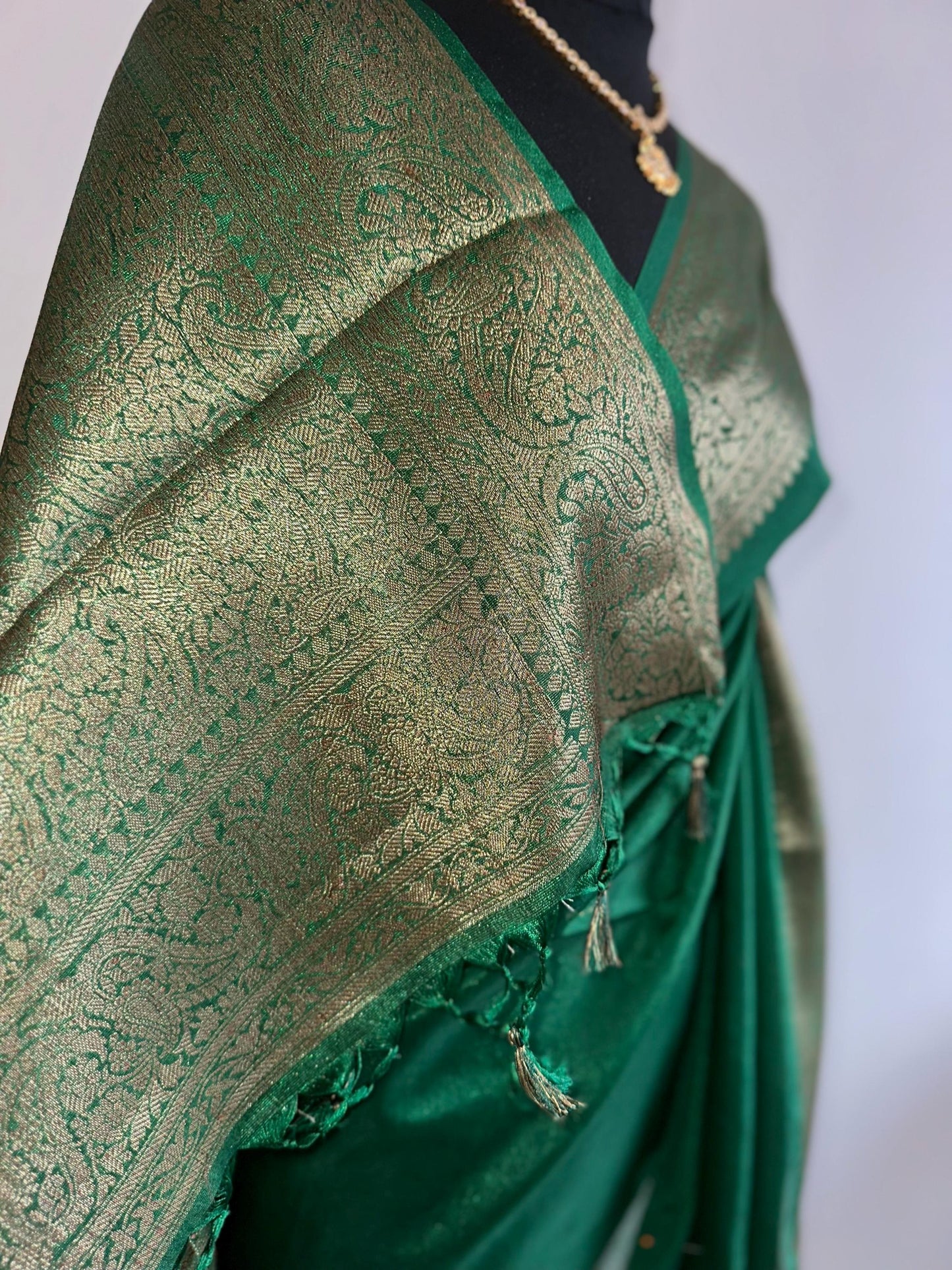 Green chiffon semi silk saree with antique gold border.