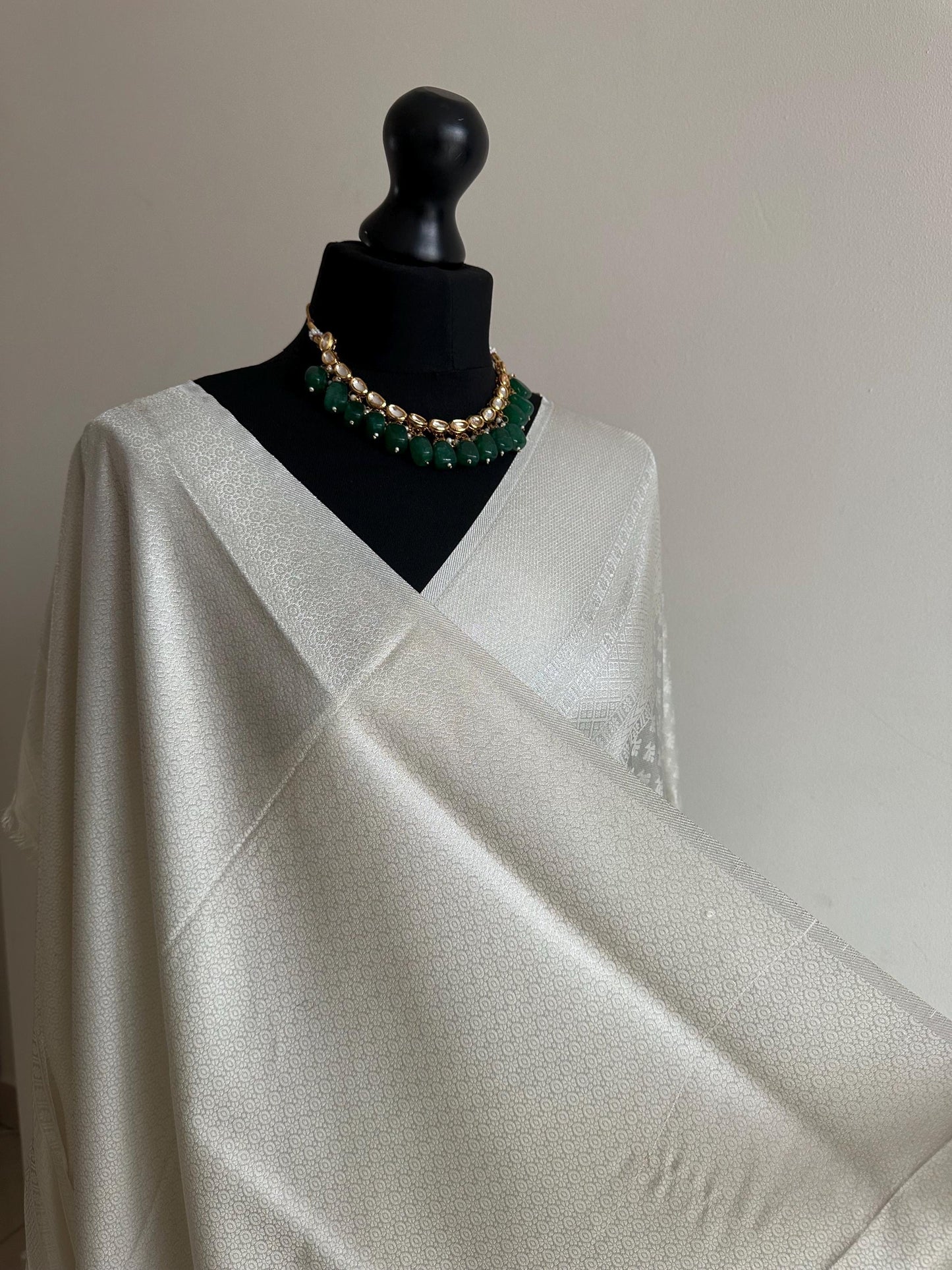 Off white and silver soft silk saree with an all over sheen. The perfect saree for parties and all traditional events.White saree for guests