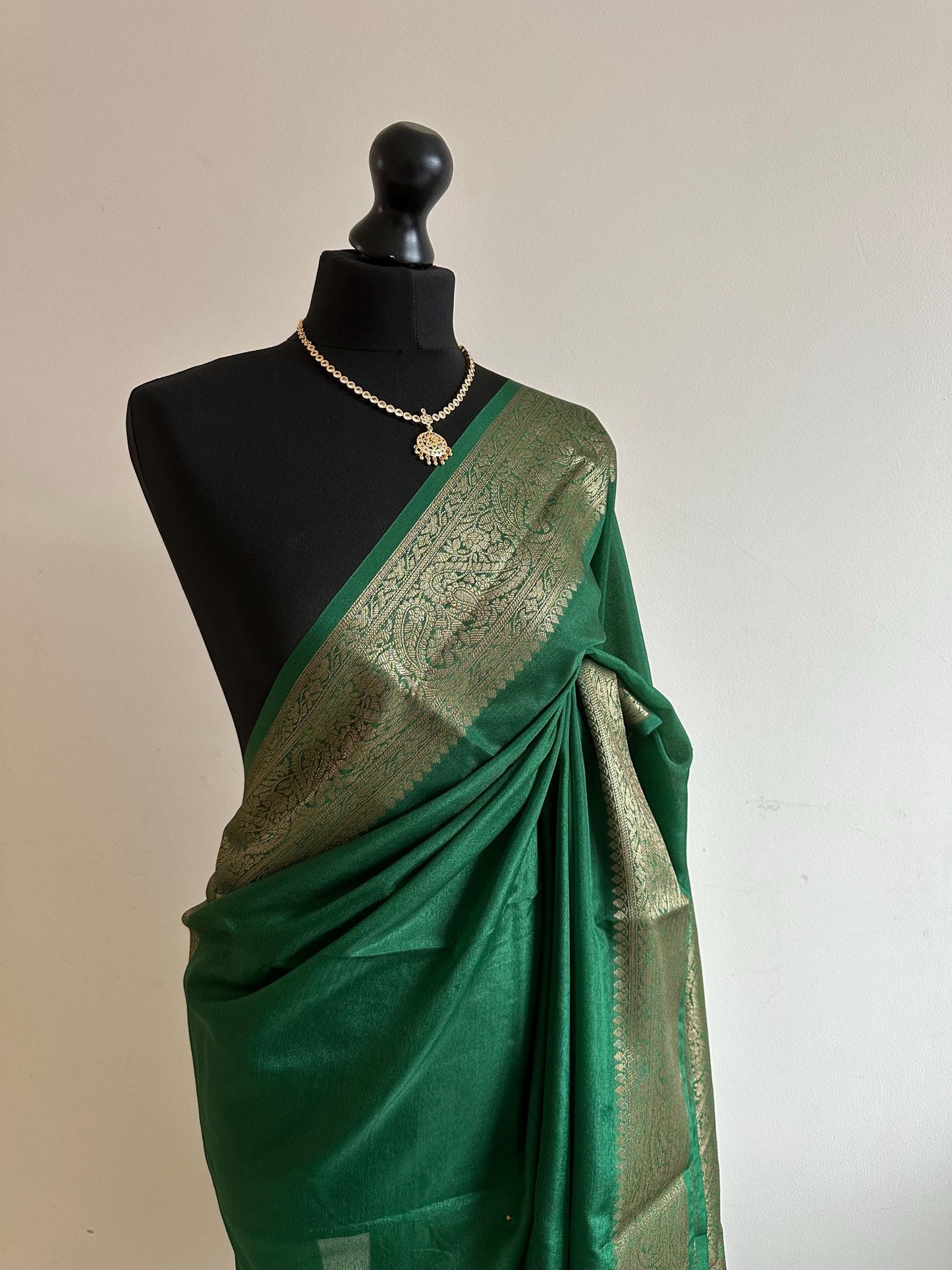 Green chiffon semi silk saree with antique gold border.