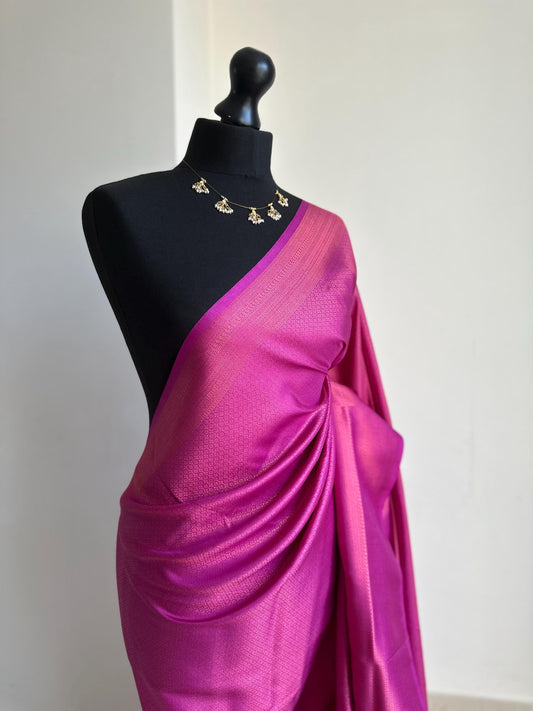 Dark pink soft silk saree with a copper border and all over sheen. This elegant rani pink saree is comes with unstitched running blouse.