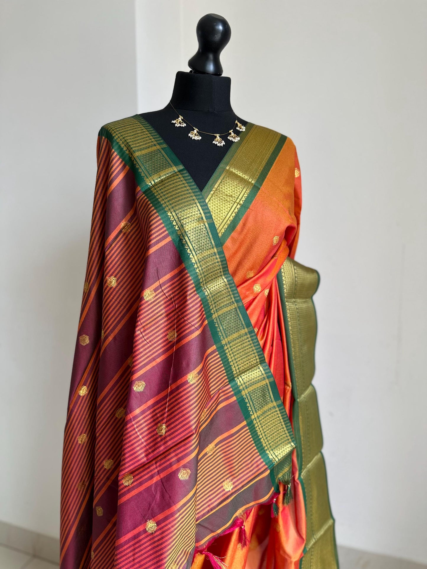 Orange and green semi silk saree with gold zari border and buti. Traditional designer saree beautiful colour and design.
