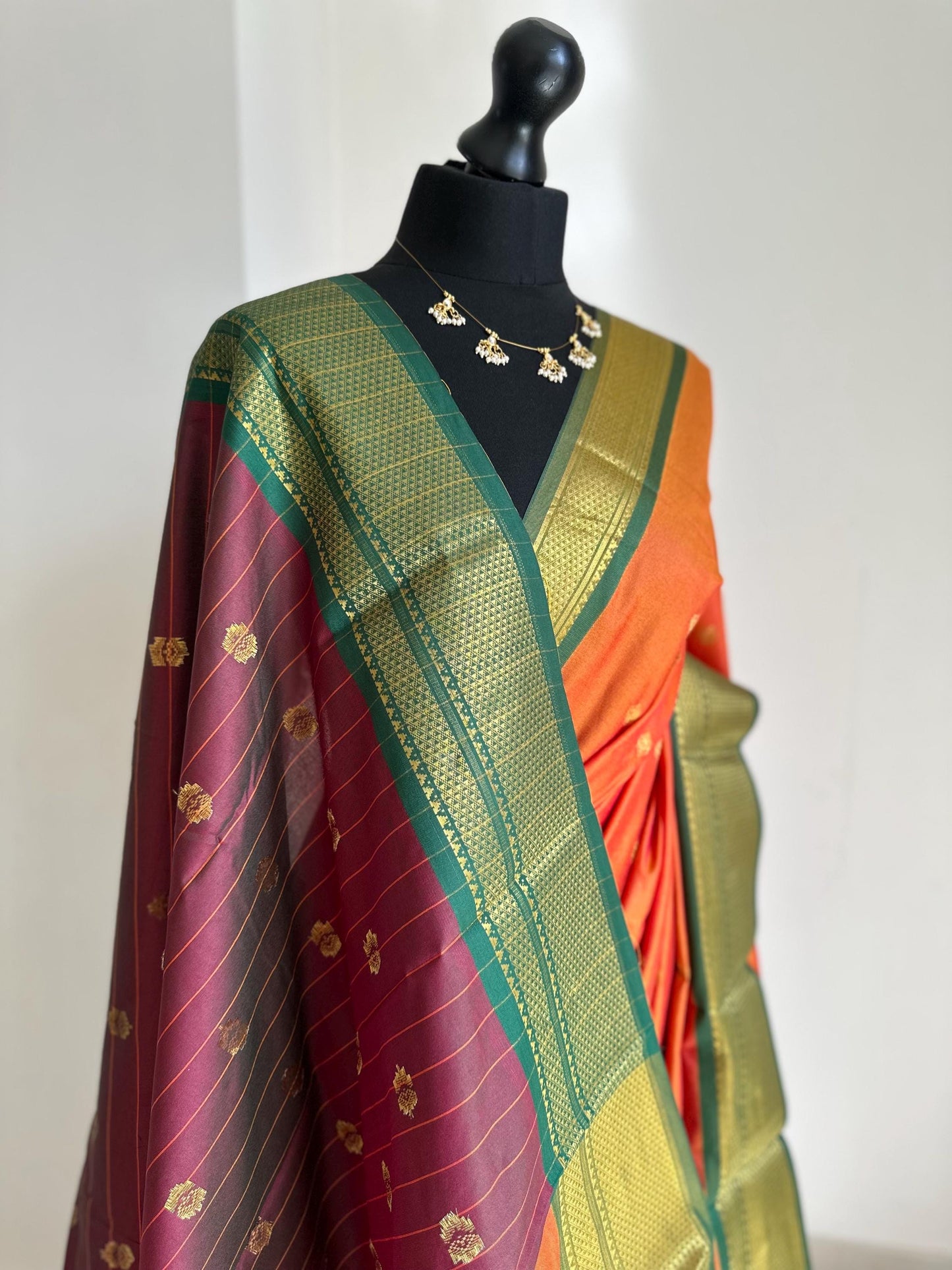 Orange and green semi silk saree with gold zari border and buti. Traditional designer saree beautiful colour and design.