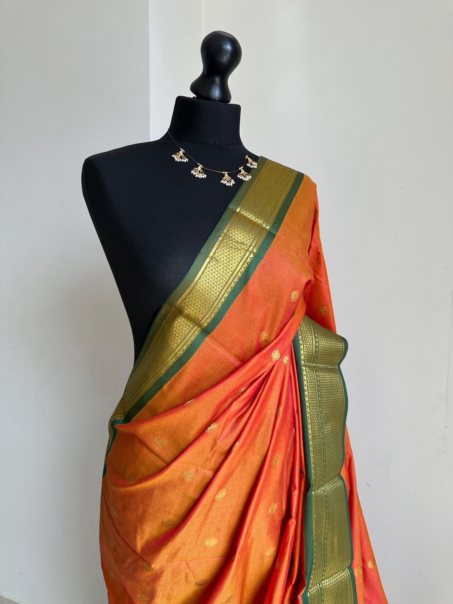 Orange and green semi silk saree with gold zari border and buti. Traditional designer saree beautiful colour and design.