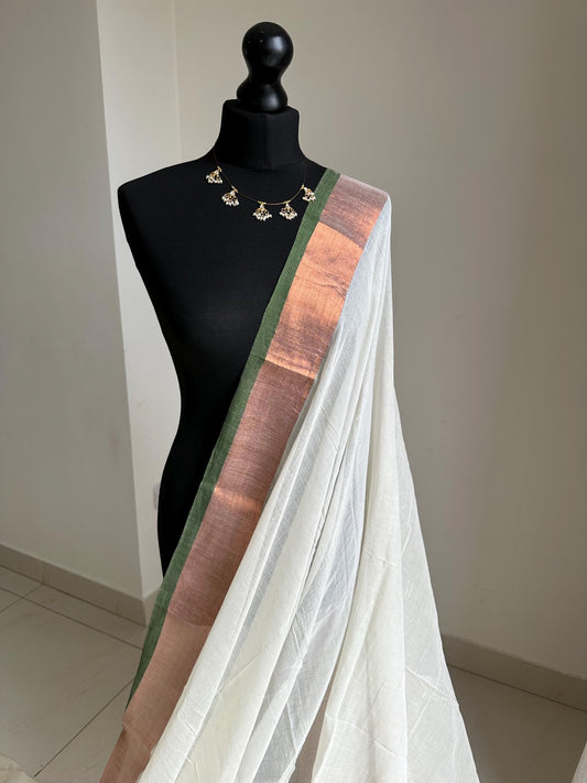 Elegant white mul cotton saree with copper zari border and green trim, lightweight handloom drape for festive and casual wear. Onam saree