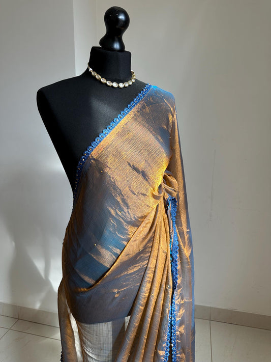 Dual toned gold party designer saree with blue trim border and contrast floral blouse. Unique statement saree can styled with other blouses