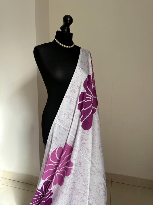 Purple floral saree with a batik-inspired design. Crafted from soft satin, this versatile piece is perfect for parties and evening occasions