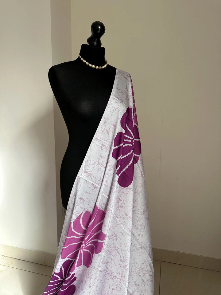 Purple floral saree with a batik-inspired design. Crafted from soft satin, this versatile piece is perfect for parties and evening occasions LaiLai Sarees
